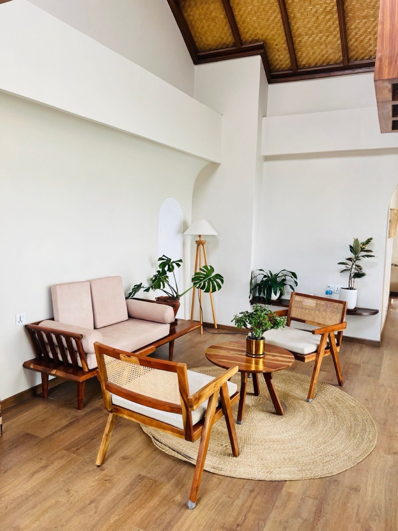 Sala de așteptare cu fotolii din ratan, perne și plante